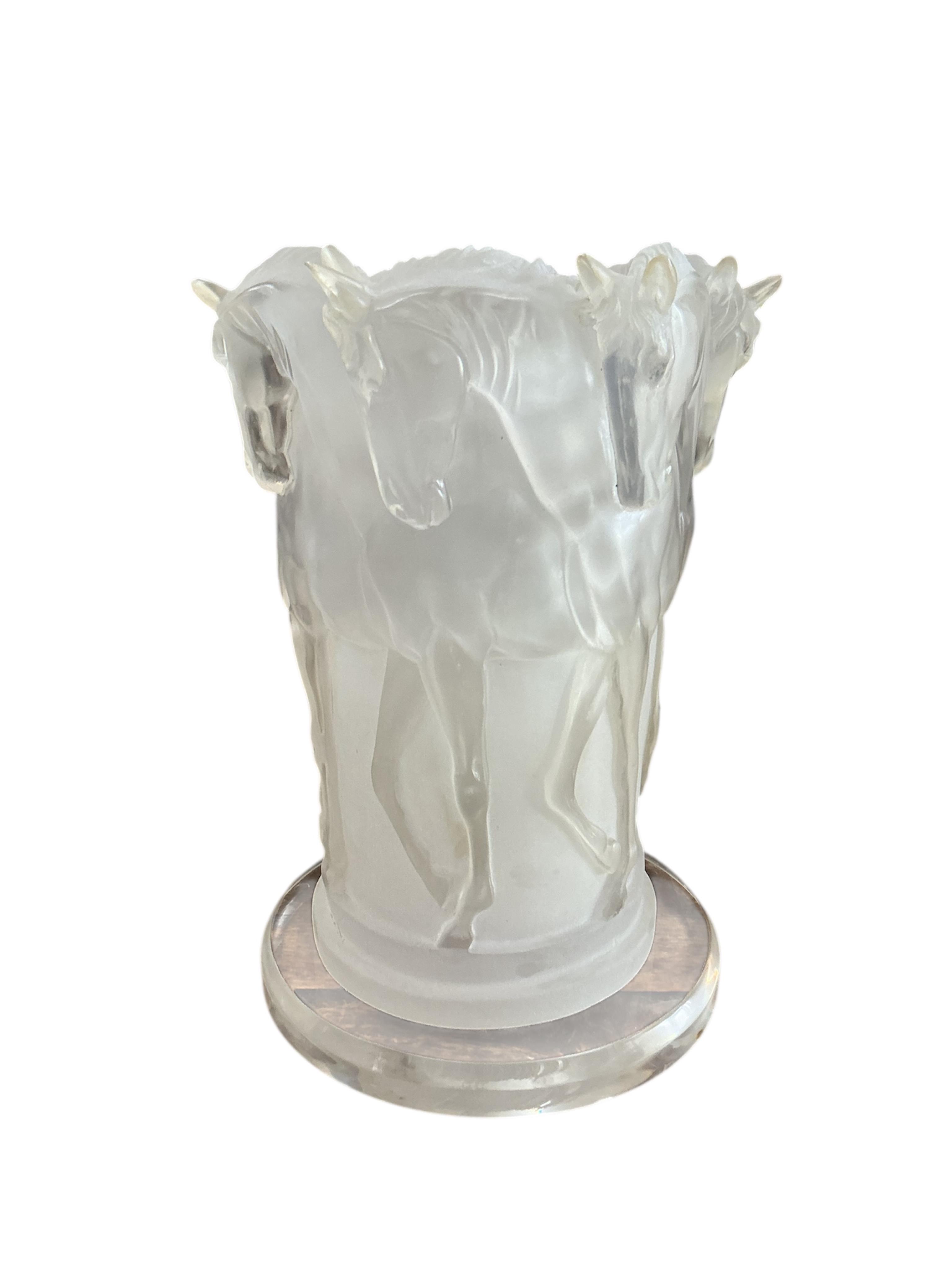 A Lucite table lamp moulded with a band of horses, 31cm high.